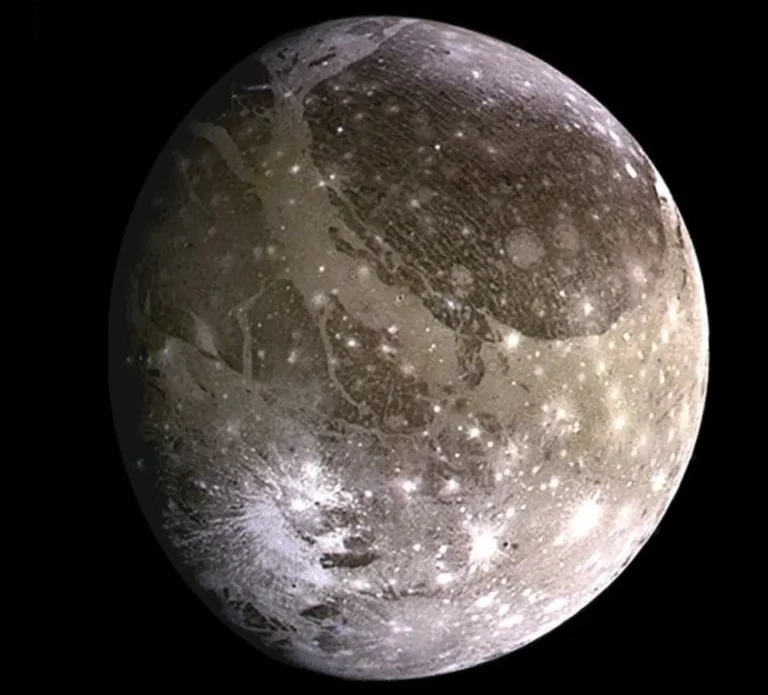 Ganymede, the largest of the moons of Jupiter, showcasing its icy and cratered surface with visible ridges and grooves.